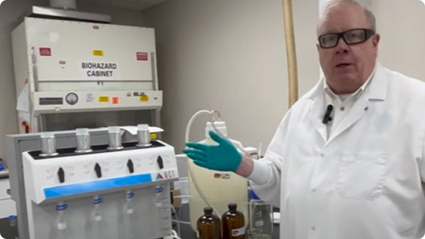 Lab technician demonstrating Enviro-Clean Universal system for EPA Method 1664 oil and grease extraction using XL system